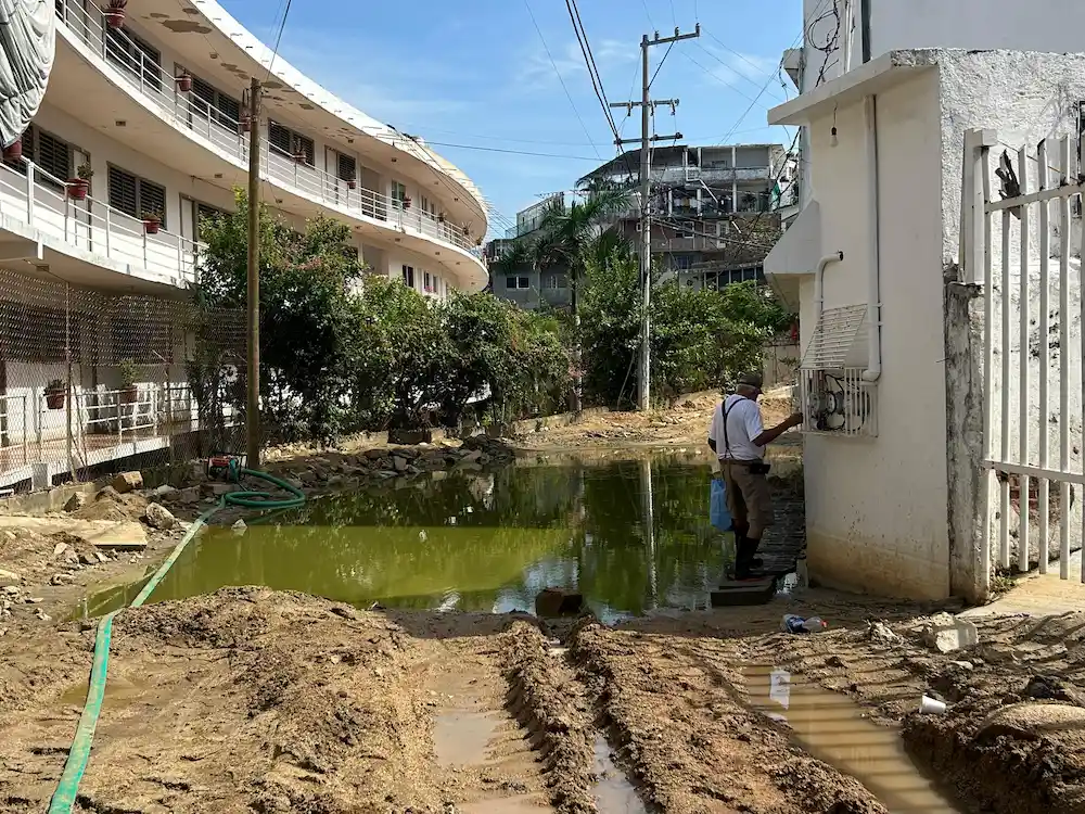 Caminan entre piedras y drenaje por la inconclusa pavimentación en Las Playas de Acapulco